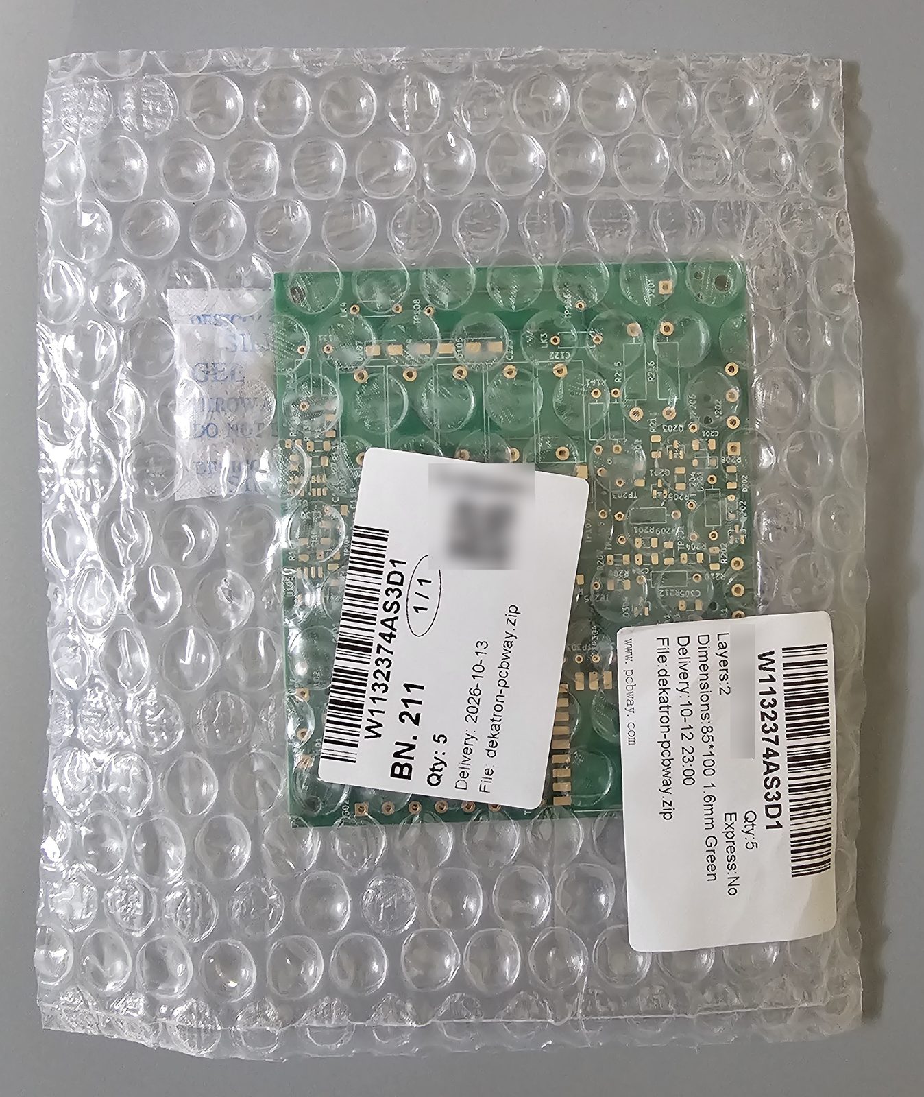 The dekatron boards as delivered: sealed in bubble wrap with a silica-gel desiccant pack and PCBWay's order labels